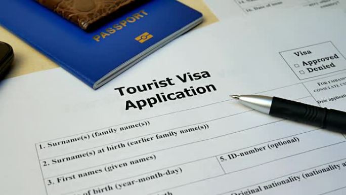 带护照和笔的旅游签证申请表