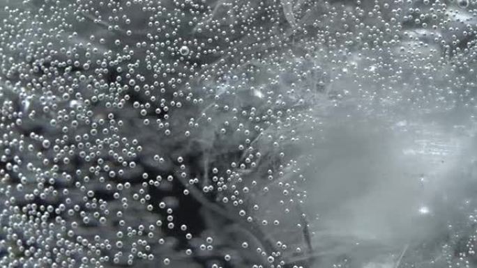 Bubbles on glass with sparkling water in rotation