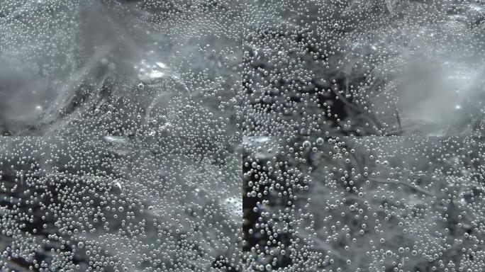 Bubbles on glass with sparkling water in rotation