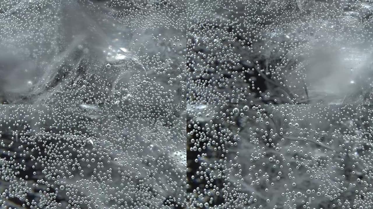 Bubbles on glass with sparkling water in rotation