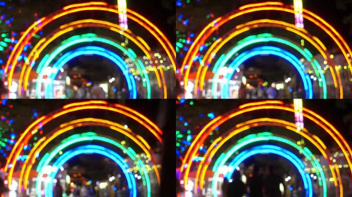晚上进入游乐园，以现代景点为背景的五颜六色的灯光。