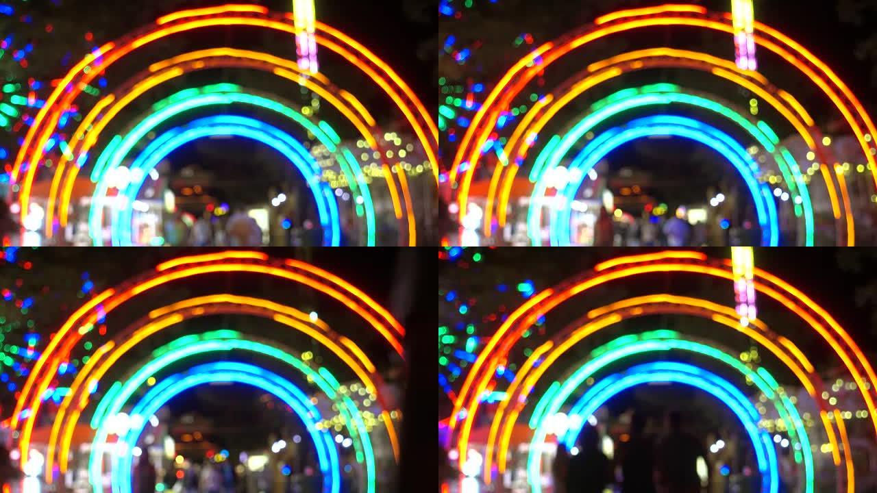 晚上进入游乐园，以现代景点为背景的五颜六色的灯光。