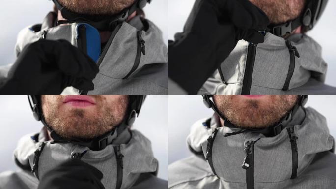 男子脸部细节关闭夹克拉链准备滑雪。登山滑雪活动。冬季滑雪者在高山户外运动。前视图。慢动作60p 4k