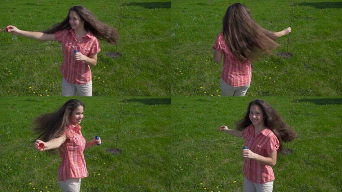 年轻女孩在春天公园用肥皂泡旋转