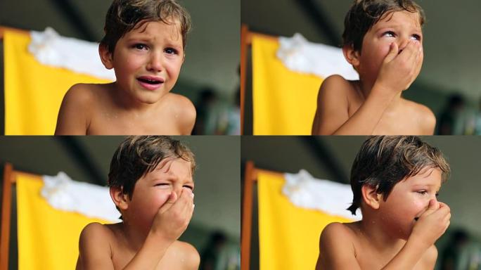 哭泣的孩子在观察周围以引起注意时会擦伤鼻子。哭泣的小男孩带着悲伤的表情抽泣