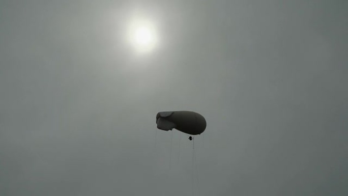 飞艇齐柏林飞船气体氦气漂浮在天空中的太阳背景在灰色的傍晚天空上观察环境并进行气象观测