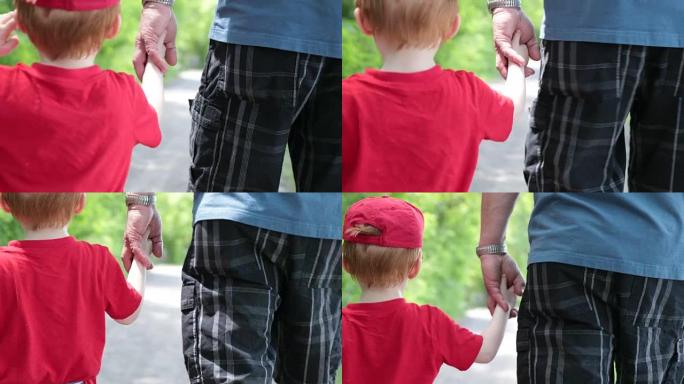 爷爷和孙子在户外散步时手牵着手