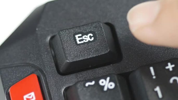 人体手指按下计算机键盘上的逃生按钮的特写
