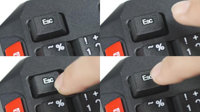 人体手指按下计算机键盘上的逃生按钮的特写