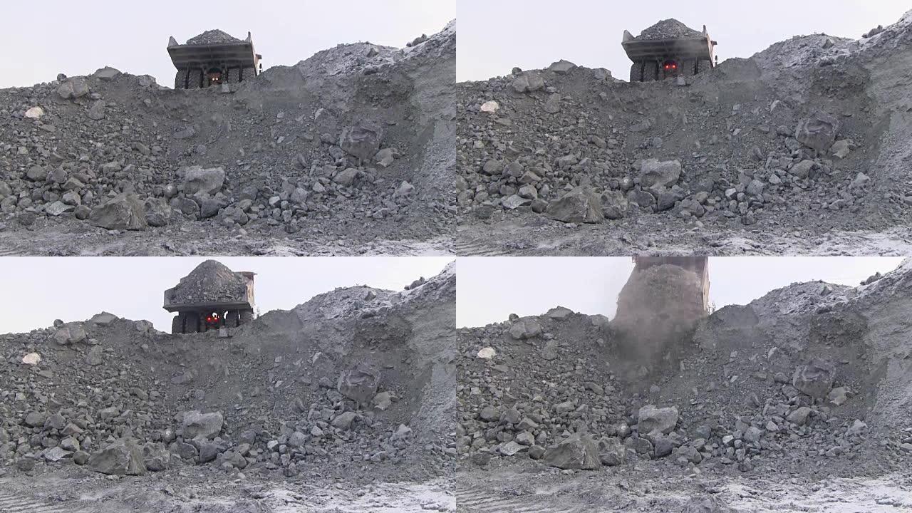 一辆大型自卸车将50吨矿石倒入悬崖。