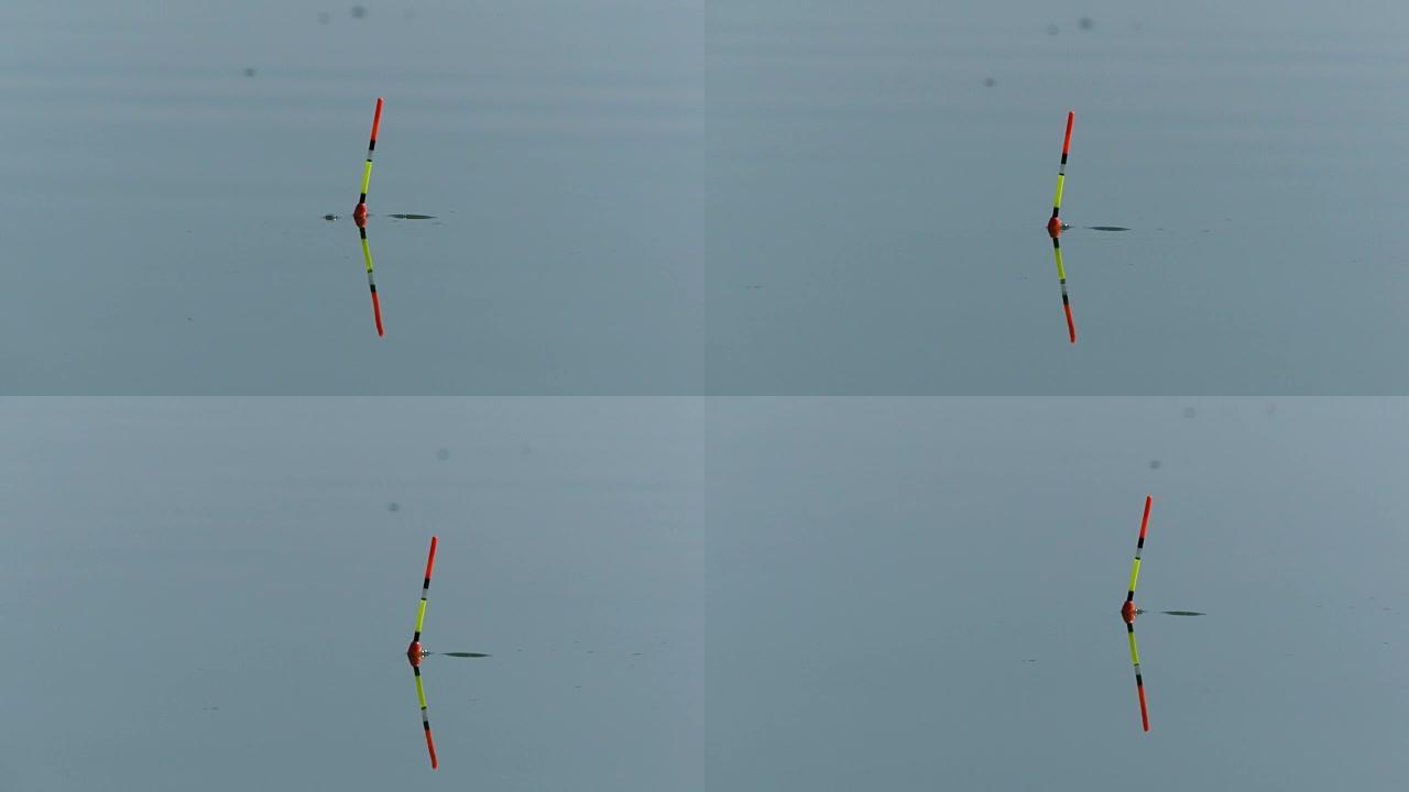 钓鱼时在水中钓竿的浮子。水中的漂浮物表明鱼正在咬人。