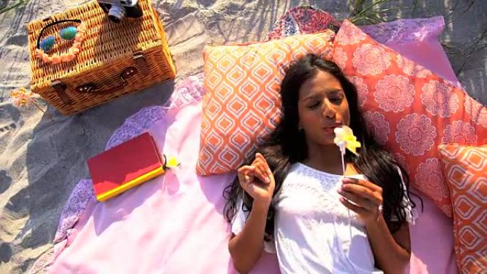 亚洲印度妇女在海滩野餐时穿着风车