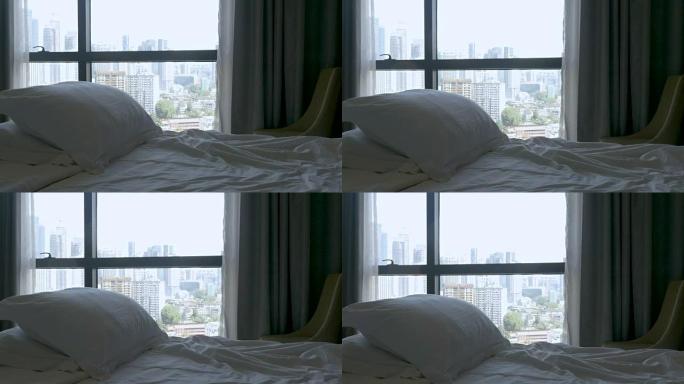 倾斜一张有两个枕头的空床，可以看到大城市的景色