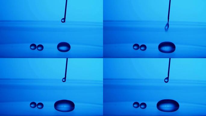 晶体水滴从实验室蓝色表面上的金属针上掉落