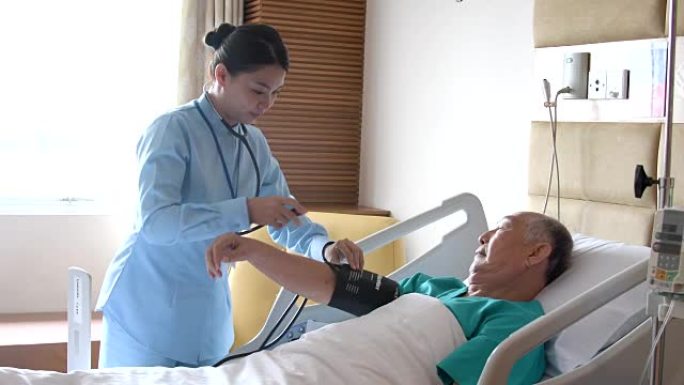 护士在医院的病床上测量老人的血压