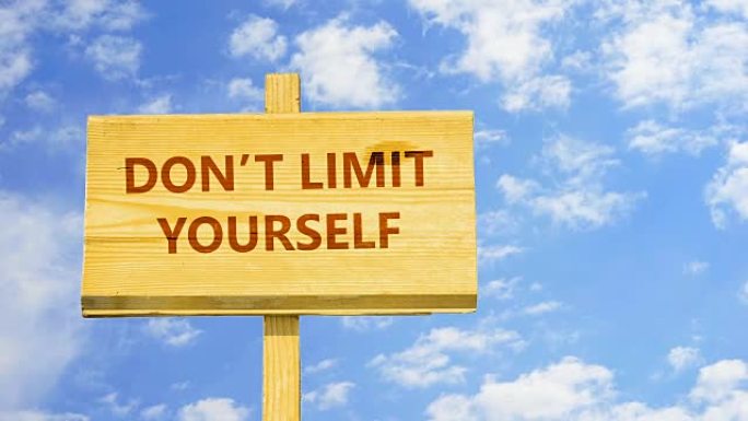 不要限制自己。木制标志上的文字与蓝天中的时光流逝的云彩。