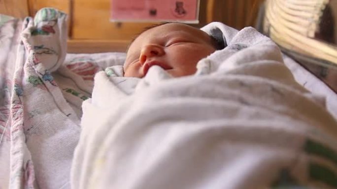 一名新生婴儿出生后在医院婴儿床睡觉