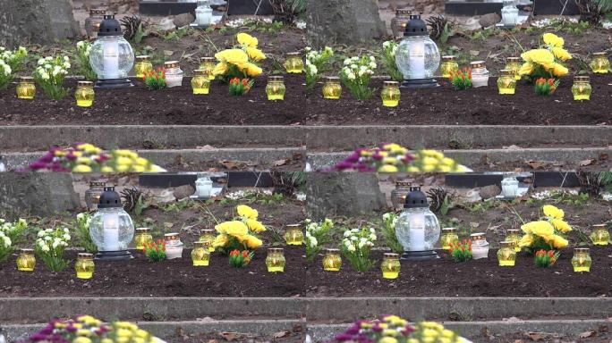黄色的蜡烛在墓地的坟地上燃烧。FullHD