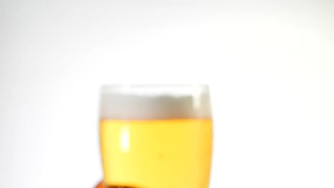 运动焦点从模糊到清晰，男人的左手拿着白色背景的冰啤酒。