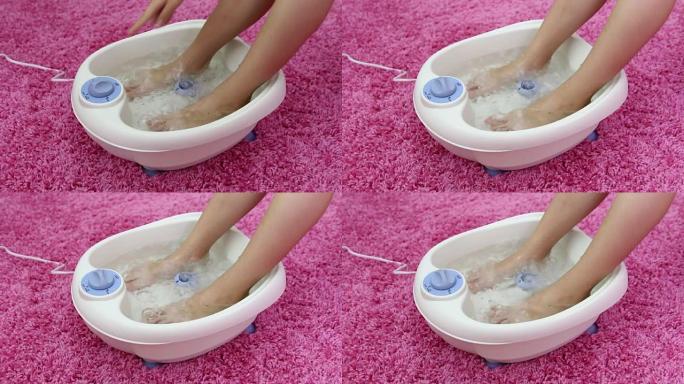 振动足部水疗按摩器中的女性脚。开关模式电动按摩足浴。