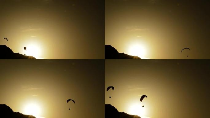滑翔伞在日落时练习滑翔伞运动，背光