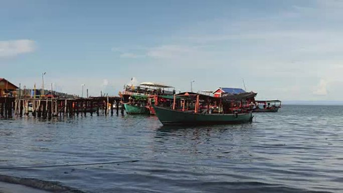 传统渔船停靠在碧蓝天空下的木码头
