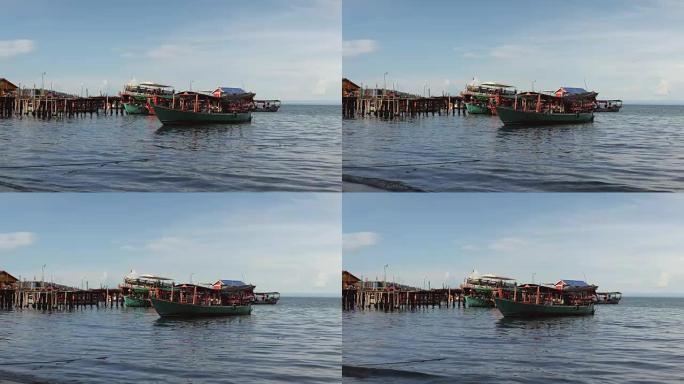 传统渔船停靠在碧蓝天空下的木码头