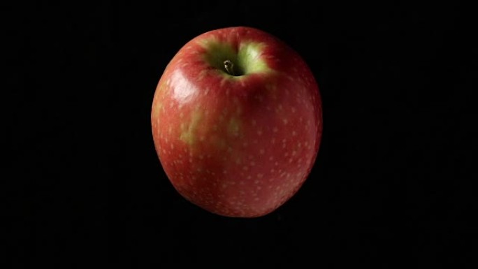 黑色背景上的旋转苹果