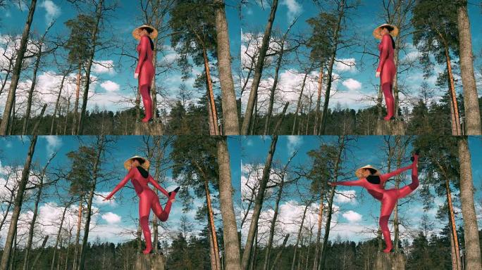 森林里的女人练习瑜伽健身运动，戴着传统帽子冥想。4k慢动作