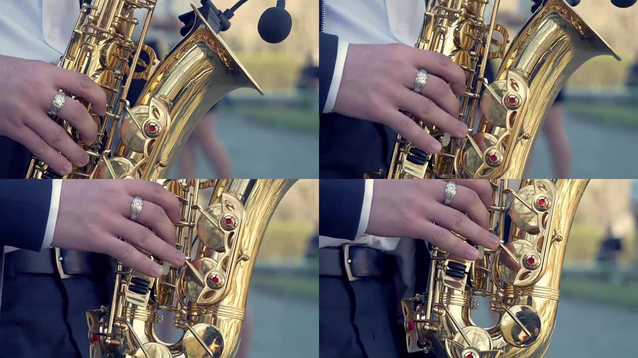 新郎的手在萨克斯管上演奏。特写镜头的人演奏金色中音萨克斯管，效果轻盈。演奏萨克斯管的人。男人演奏萨克