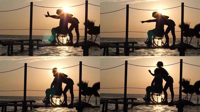 幸运的跛子在轮椅上和女人看地平线在美丽的日落背景在夏季旅行