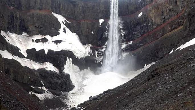 视频的黑暗，强大的瀑布在山上，有大量的水喷雾。冰岛