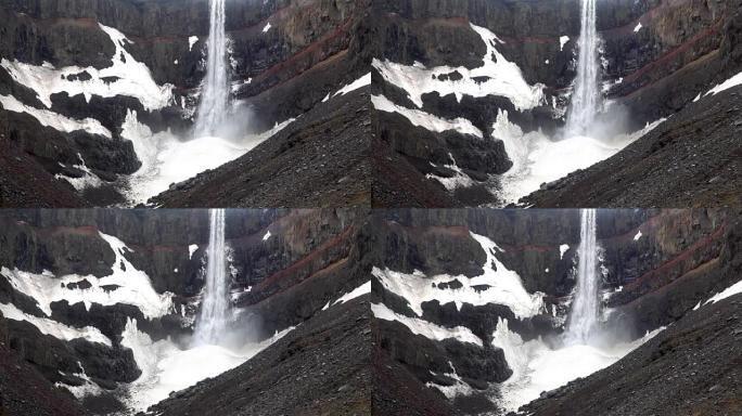视频的黑暗，强大的瀑布在山上，有大量的水喷雾。冰岛