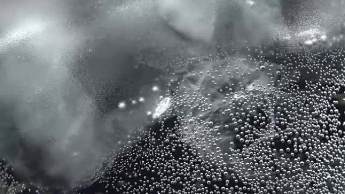 Bubbles on glass with sparkling water in rotation