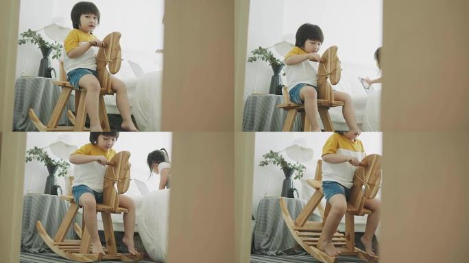 亚洲可爱的男孩和他的保姆坐在卧室的马凳上