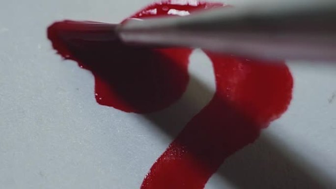 画笔在白纸画布上绘制红色水彩心
