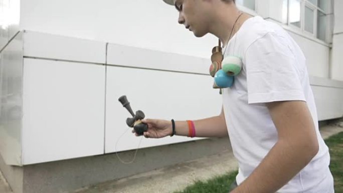 青少年通过在秒杀慢动作中抓住kendama ball来锻炼才华