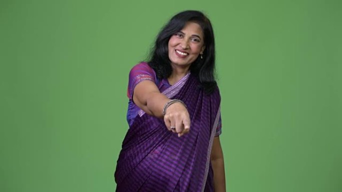 成熟快乐美丽的印度女人穿着纱丽传统服装指着相机