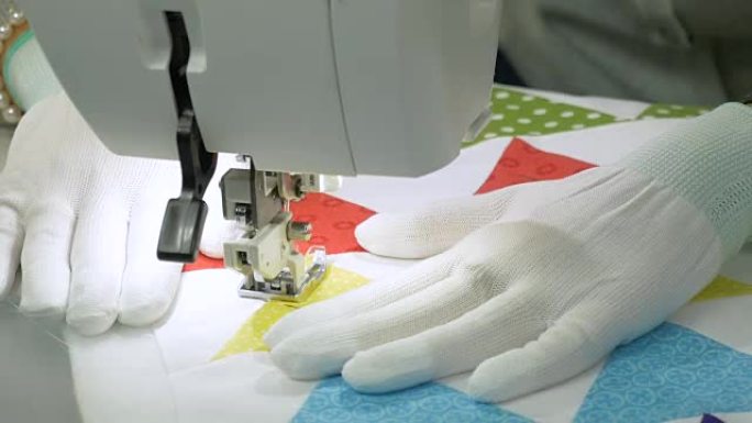 用白手套缝制裁缝，在缝纫机上缝制织物。