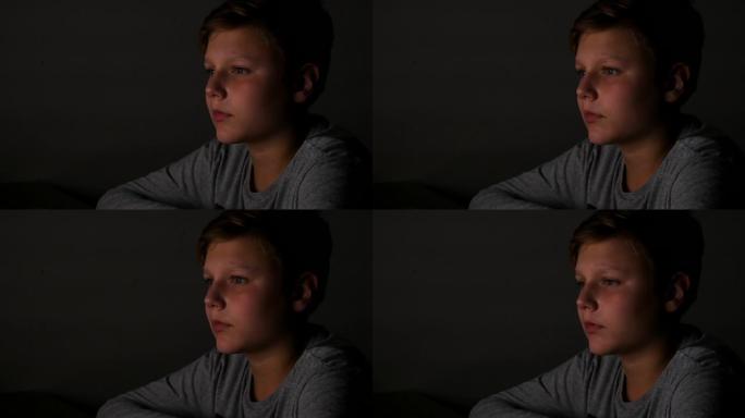 小男孩在黑暗中看电视