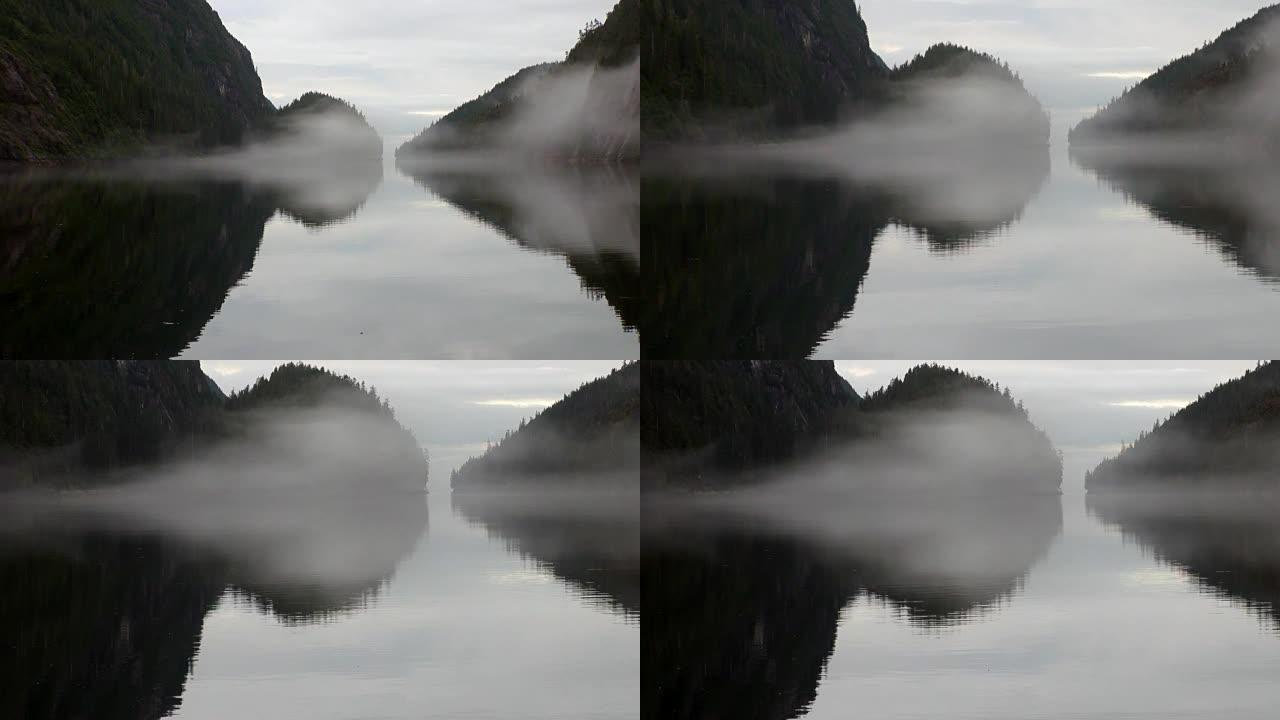 太平洋平静水背景下的雾中的山脉。