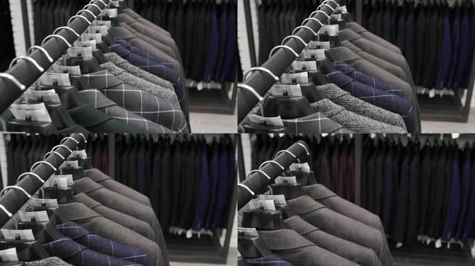 裁缝店的男式西装。男人的手在衣柜里选择一件夹克。男性选择