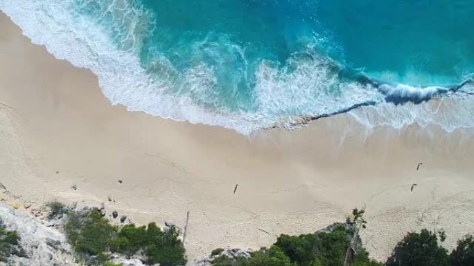 4k无人机镜头在海滩上撞击海浪的鸟瞰图。