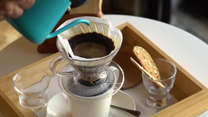 咖啡师用咖啡将水倒入过滤器，冲泡咖啡。