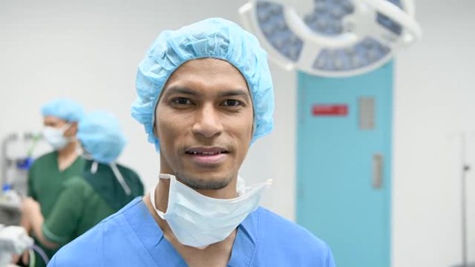 穿着磨砂膏的男性外科医生在镜头前微笑