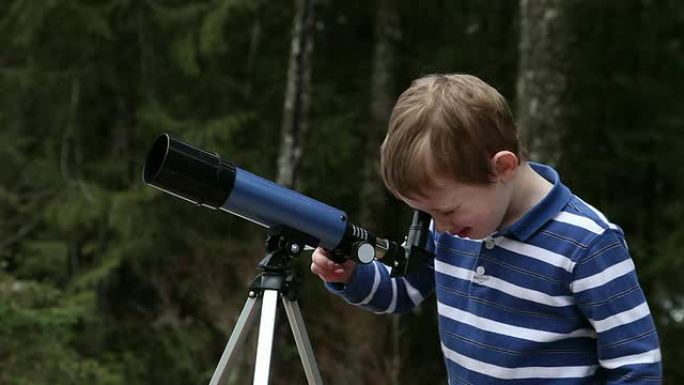 通过望远镜看的小男孩