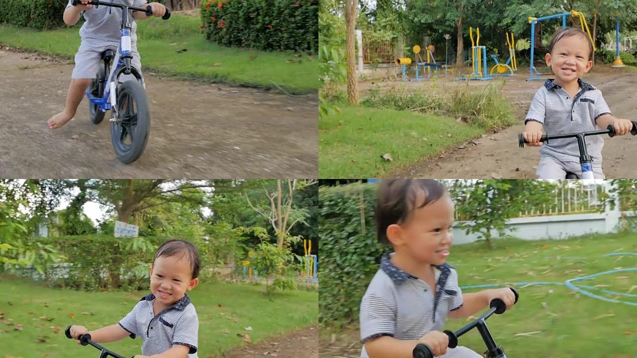 可爱的亚洲小男孩光着脚骑自行车玩得开心。孩子在骑自行车时学会保持平衡。