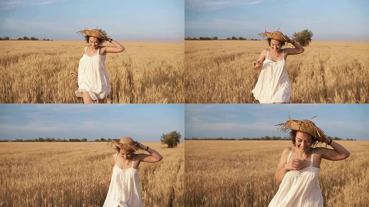 穿着白色连衣裙的漂亮年轻女子在麦田里跑。微笑着，快乐的女性跑步，头上戴着草帽。前视图