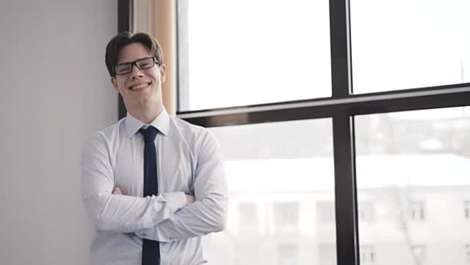 Portrait of happy man standing at window and smili