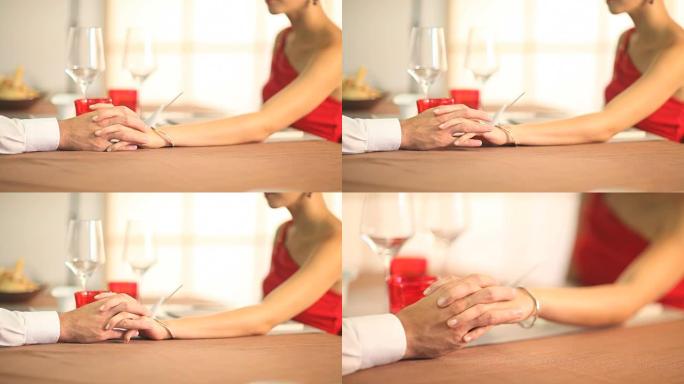 双手爱抚恋爱中的浪漫情侣共进晚餐情人节餐厅特写